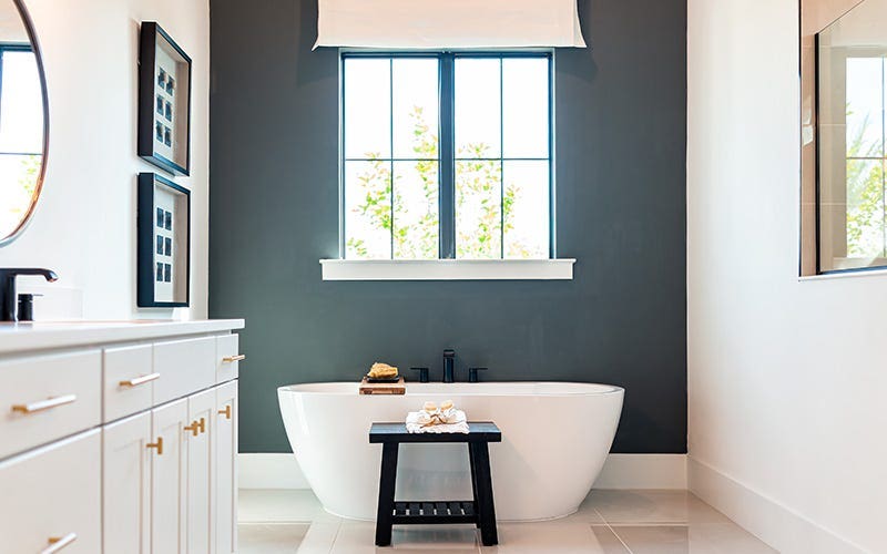 A spacious bathroom with a stylish bathtub and a sleek sink, designed for comfort and relaxation.