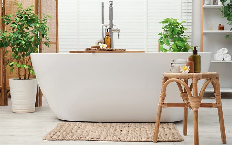 A bright white bathtub accompanied by a stool, enhancing the bathroom's functionality and style