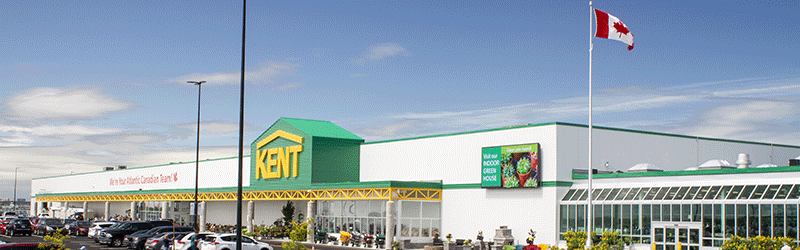 KENT Building Supplies prominently features a Canadian flag waving atop its roof against a clear blue sky