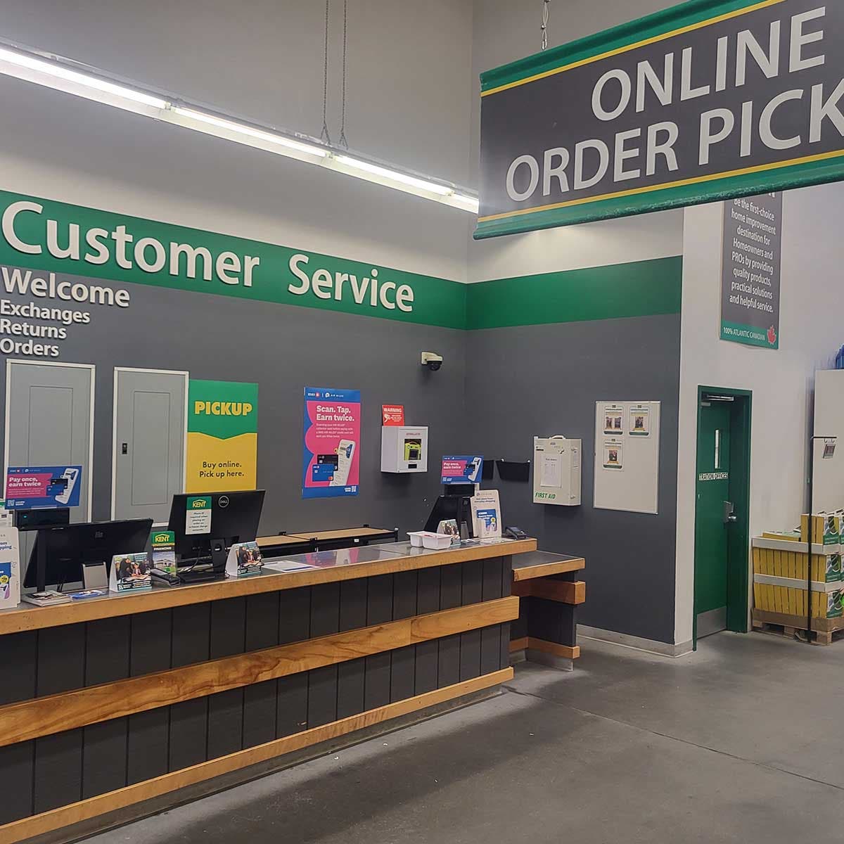 Customer service counter inside a retail store with online order pickup signage and payment terminals image